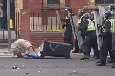 Shocking moment woman shoves wheelie bin towards cops before falling flat on her face as she admits violent disorder